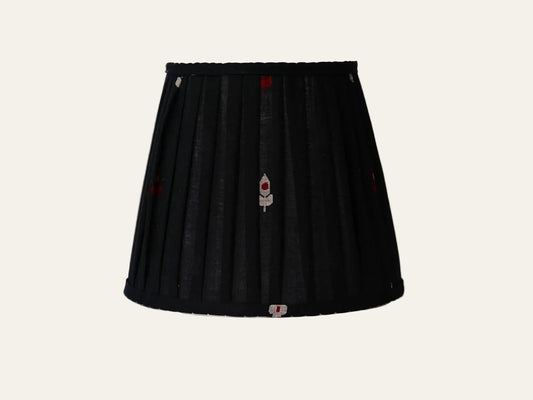 Black lampshade with embroidered designs on a white background