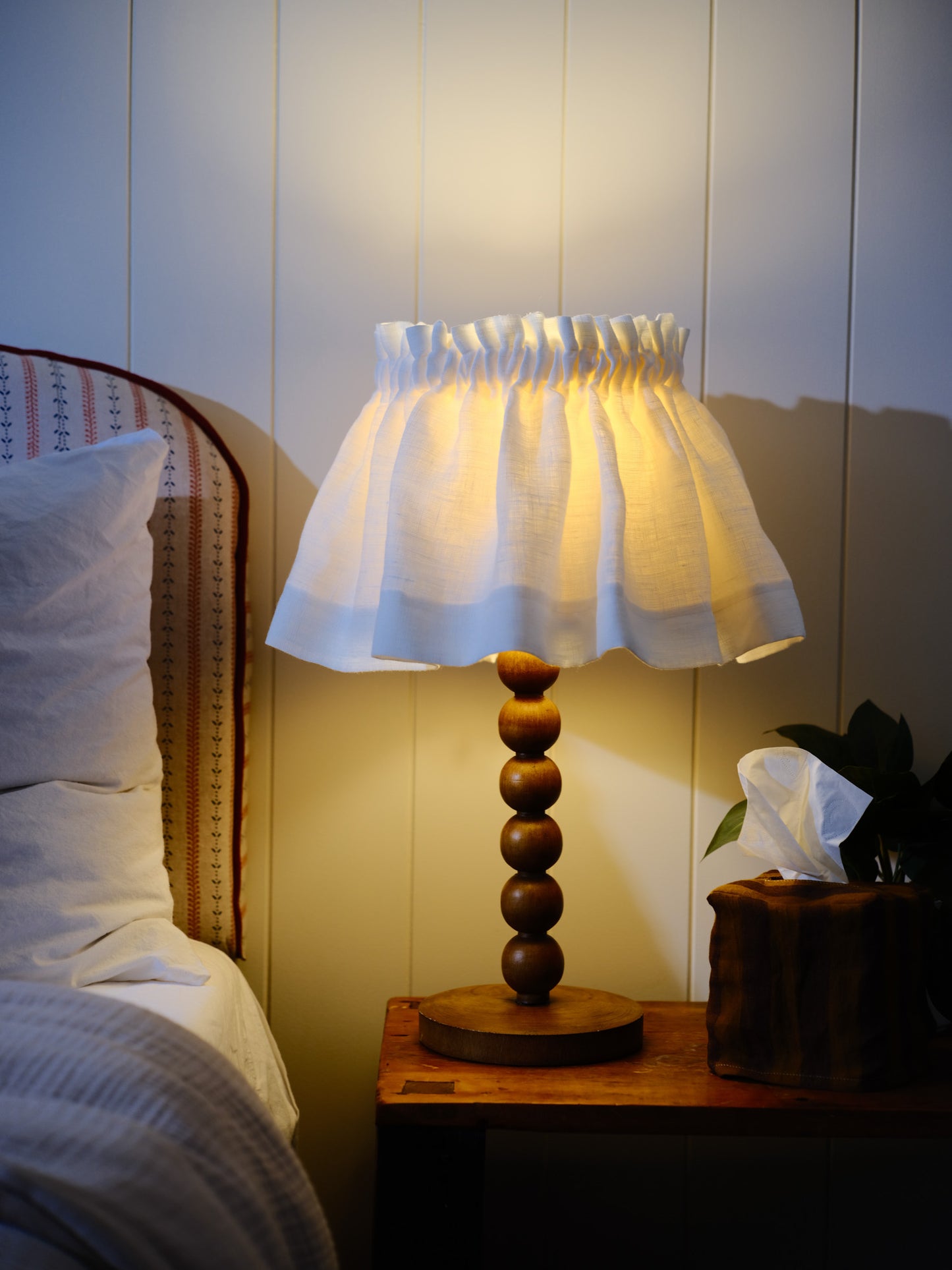 Lamp on a bedside table with a soft glow in a bedroom setting