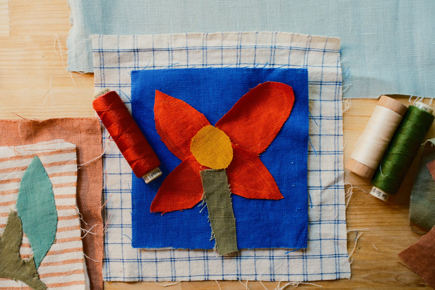 fabric scraps laid out with spools of thread