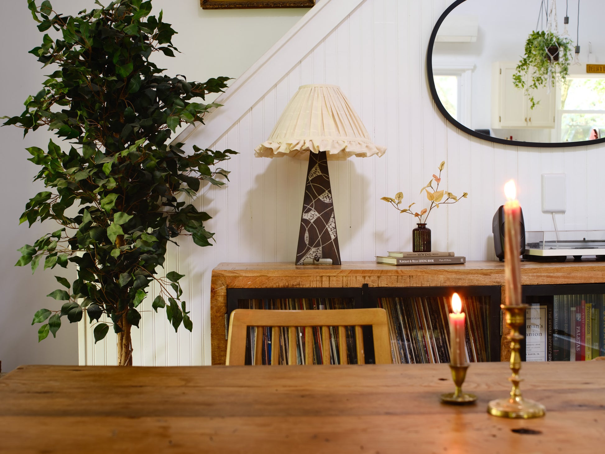 Dining room with wooden table, chair, lamp, and decorative items.