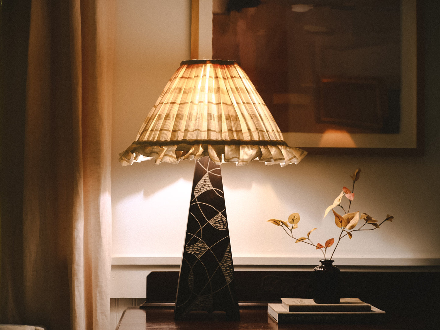 Decorative lamp with a patterned shade in a room setting.