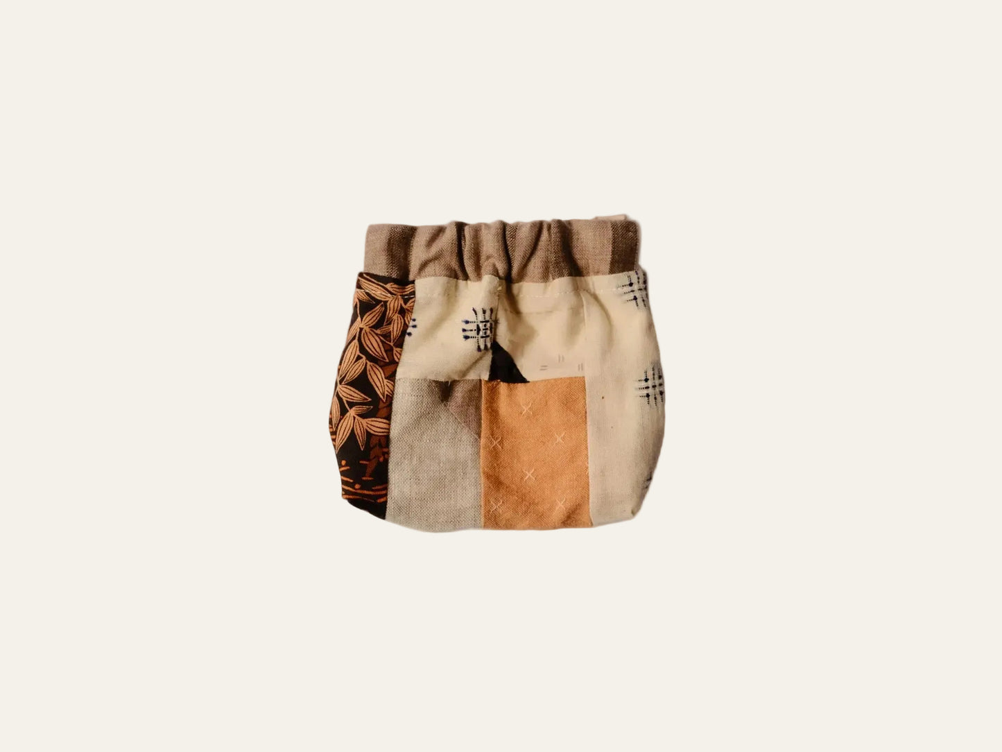 Patchwork-style bag with geometric patterns on a beige background