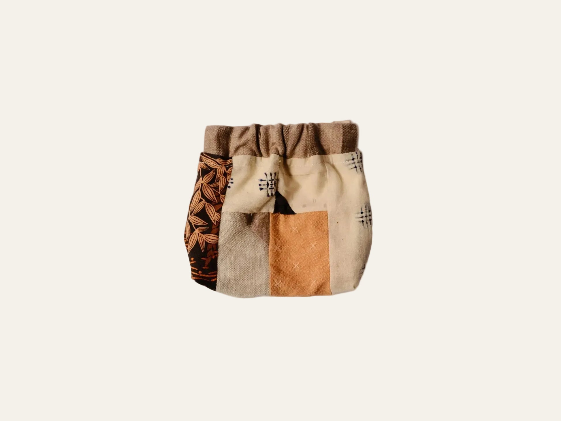 Patchwork-style bag with geometric patterns on a beige background