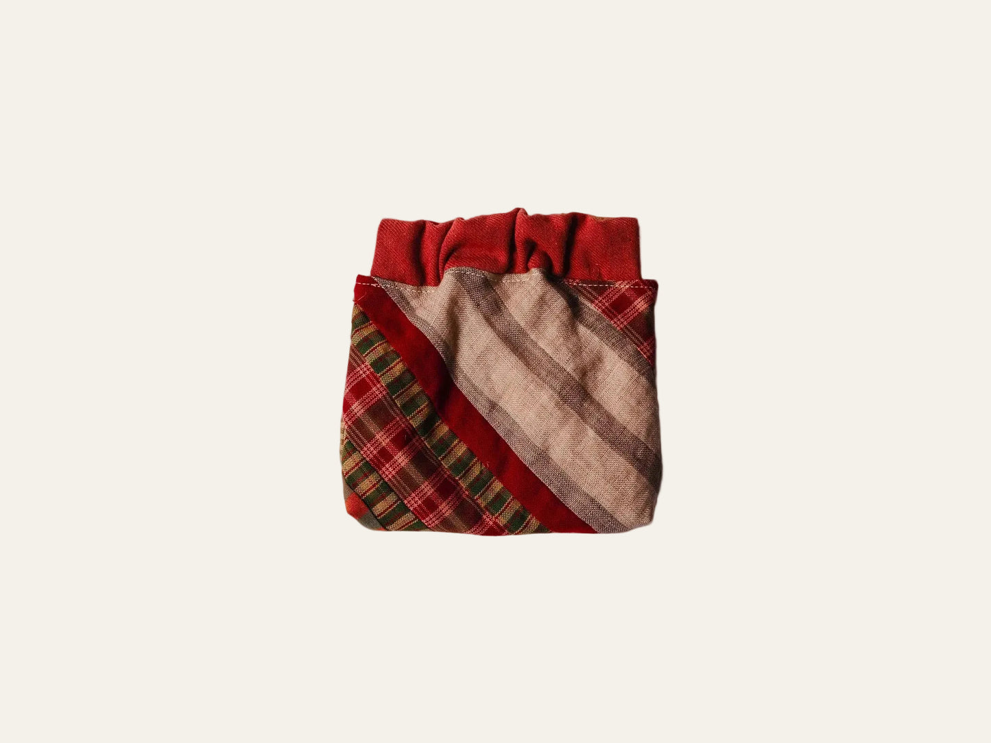 Patchwork fabric pouch with red and brown plaid pattern on a white background