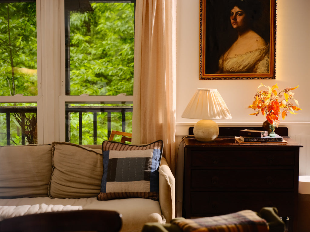 Living room with a couch, lamp, and painting on the wall