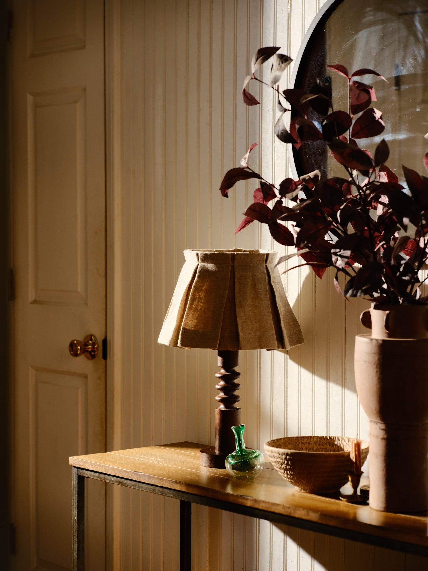 Decorative lamp and vase on a wooden surface with a neutral background