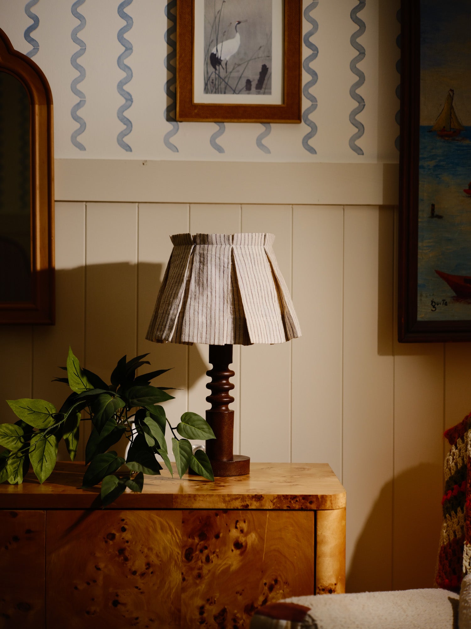 Table lamp on a wooden surface with decorative wall art in the background
