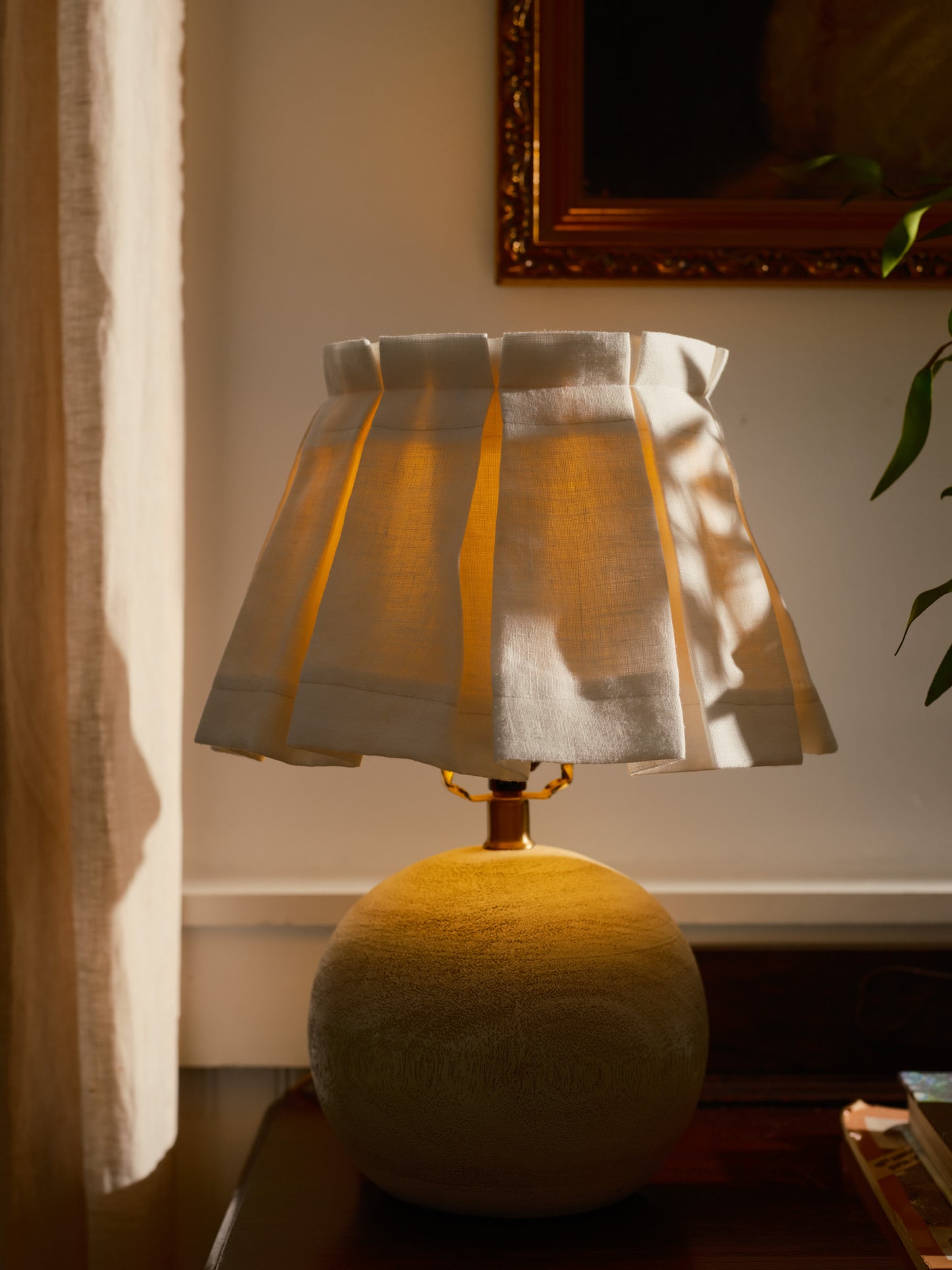 Lamp with a checkered shade on a table in a softly lit room.