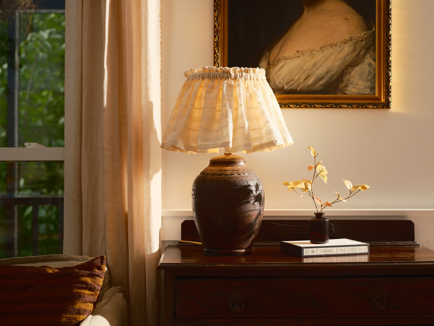 Lamp on a wooden table with a painting in the background
