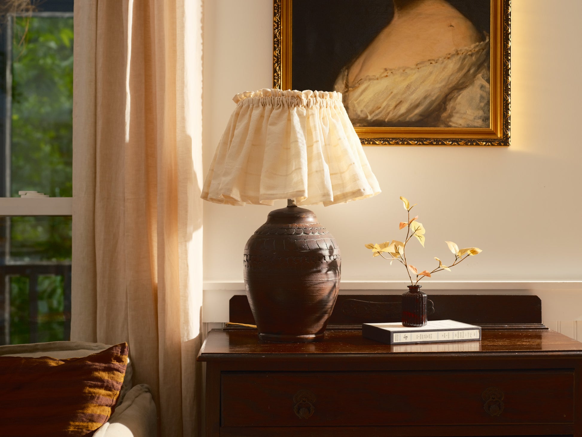 Decorative lamp on a wooden table with a painting in the background