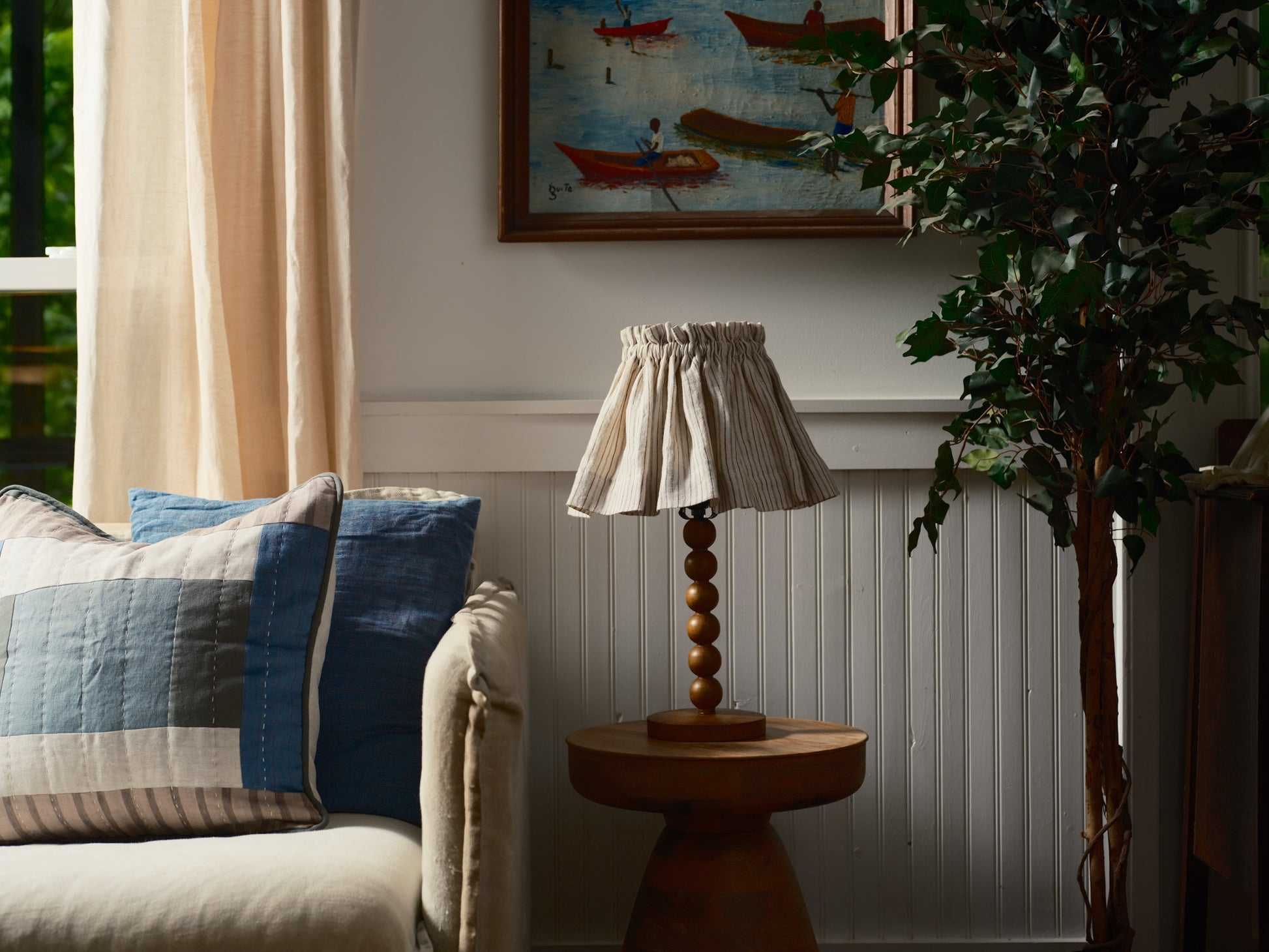 Living room with a couch, lamp, and decorative painting on the wall.