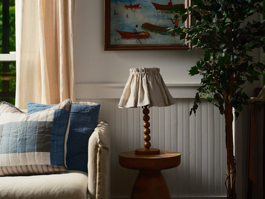 Living room with a couch, lamp, and decorative painting on the wall.