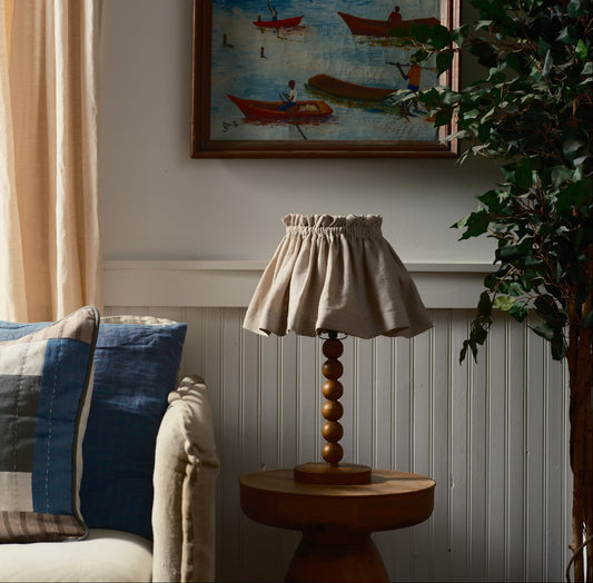 Living room with a beige sofa, decorative pillows, a lamp, and a framed picture on the wall.
