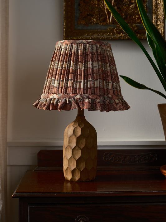 Decorative lamp with a patterned shade on a wooden surface