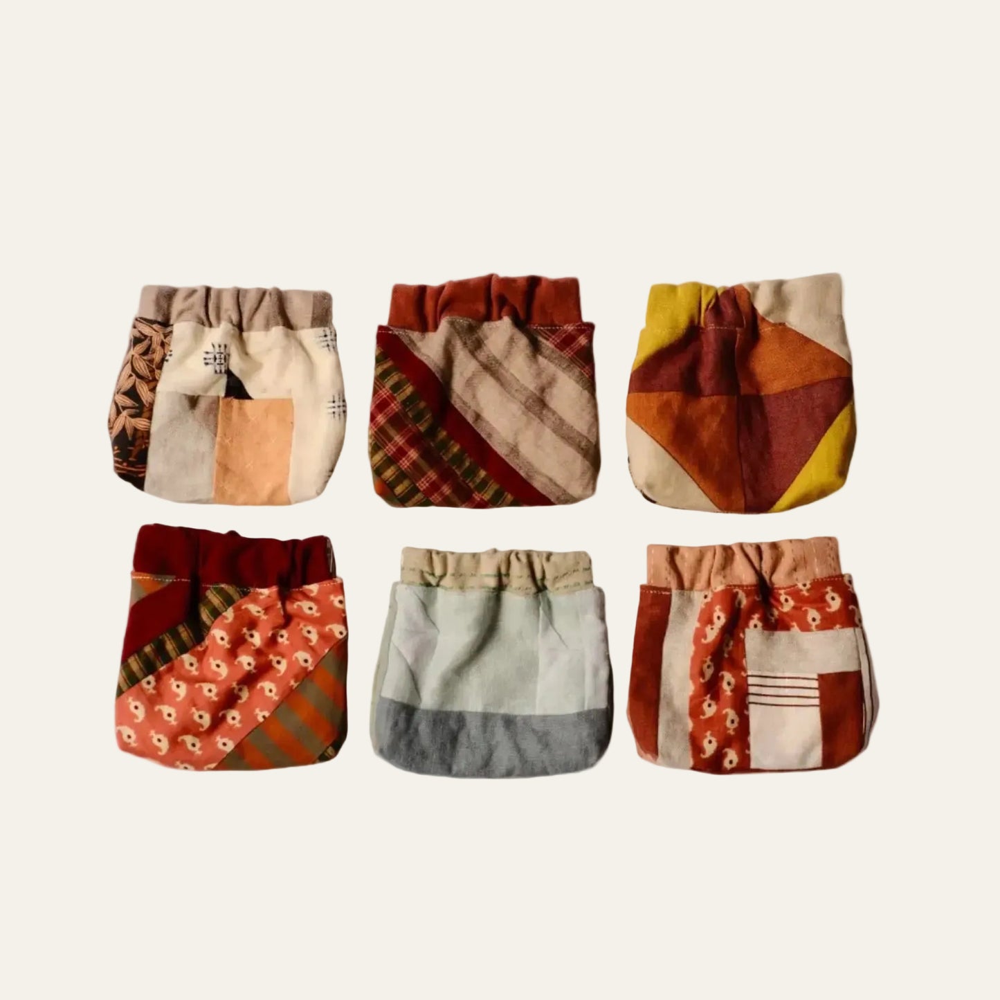 Set of six patchwork-style pouches on a beige background